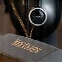 A close-up of a luxury headphone cup with a subtle, elegant custom engraving in progress, showcasing precision tools and intricate detail, in a workshop setting with artful lighting.